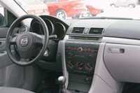 Mazda3: Салон базовой машины теряет половину своего обаяния из-за обилия серого пластика. Руль, с виду похожий на кожаный, сделан из жесткого полиуретана